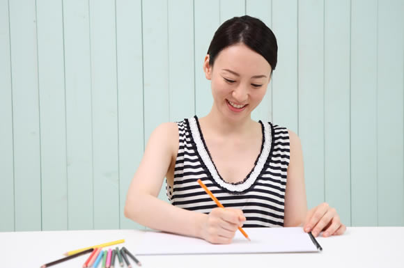 色鉛筆で作業する女性