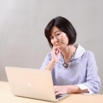 パソコンを眺める年配の女性