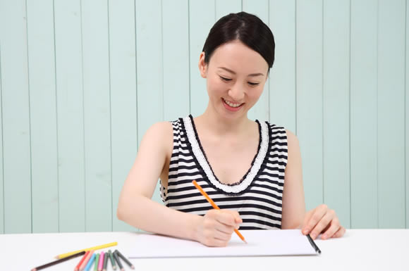 色鉛筆で書く女性